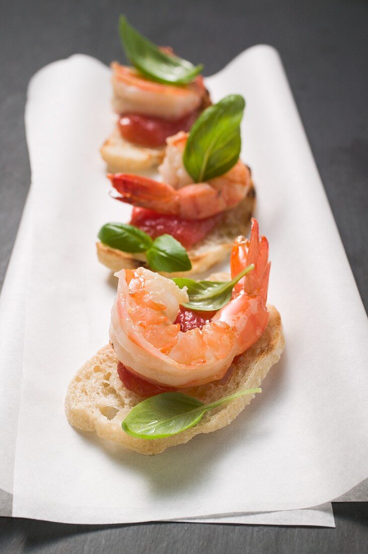 Canapés with prawns, tomatoes and basil on a napkin