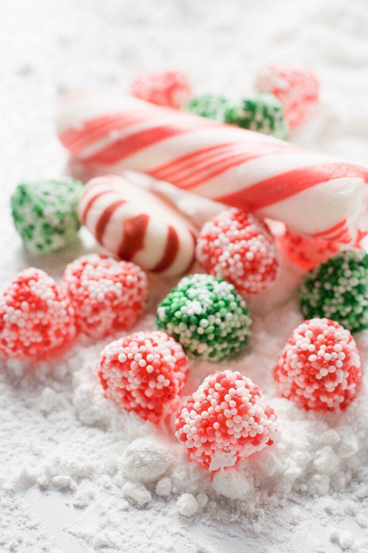 Weihnachtsbonbons und Zuckerstangen auf Puderzucker
