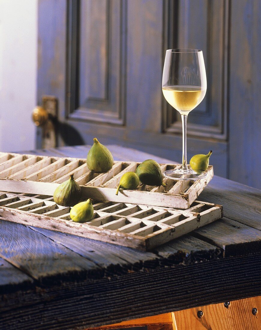 Stillleben mit einem Glas Chardonnay und frischen Feigen