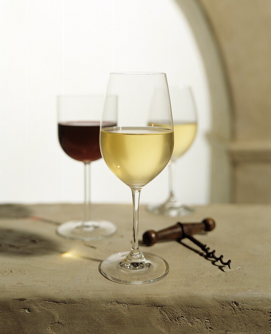 Zwei Weissweingläser und ein Rotweinglas mit Korkenzieher
