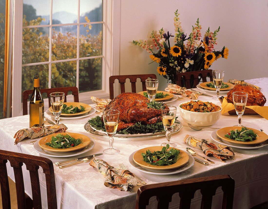 Gedeckter Tisch zum Erntedankfest mit Truthahn, Salat, Wein
