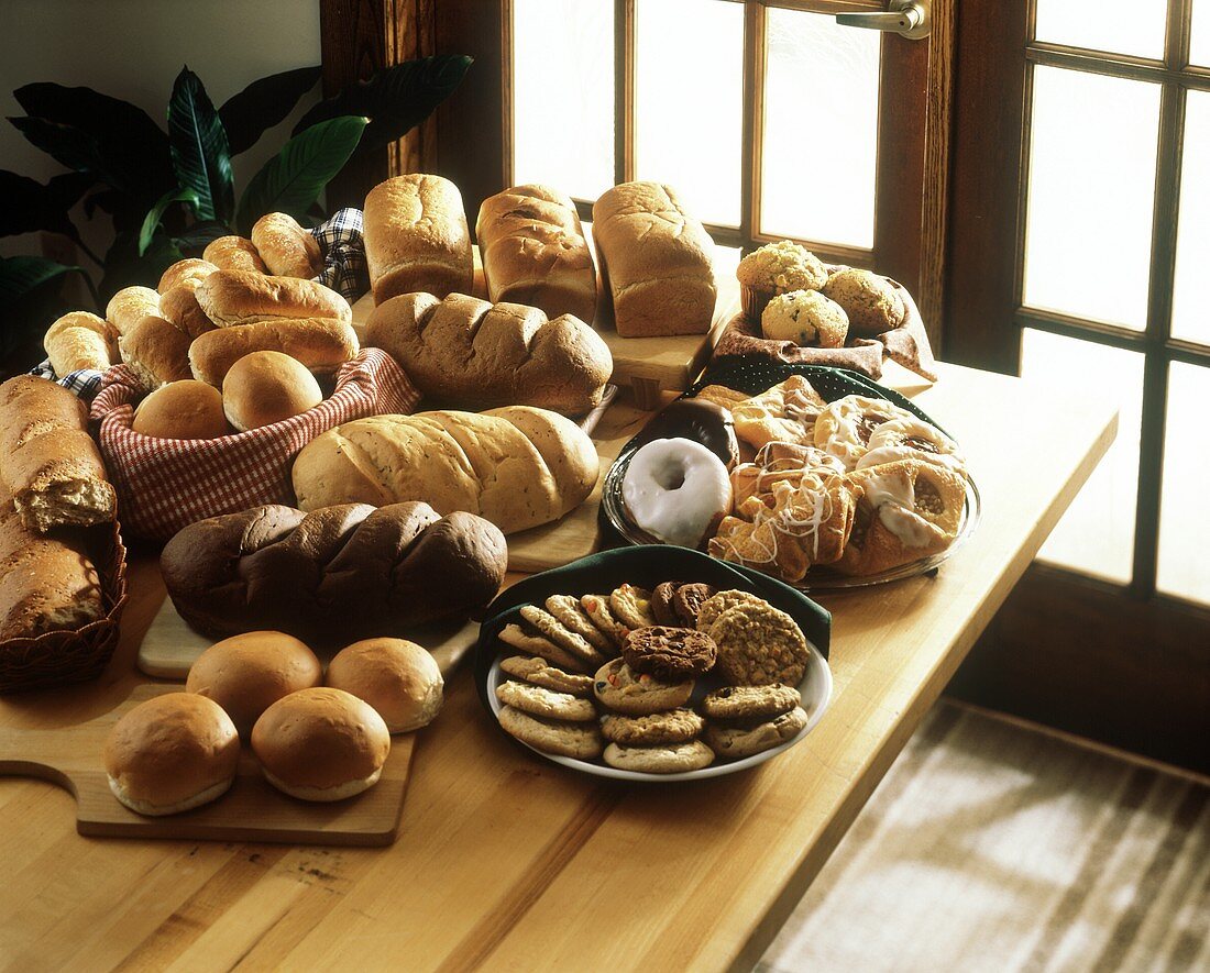 Stillleben mit Broten, Brötchen, Gebäck und Keksen auf Tisch