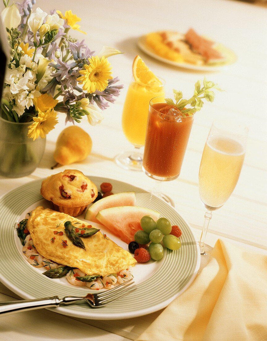 Omelett mit Shrimps und Spargel, Muffin, Obst; Sekt, Säfte