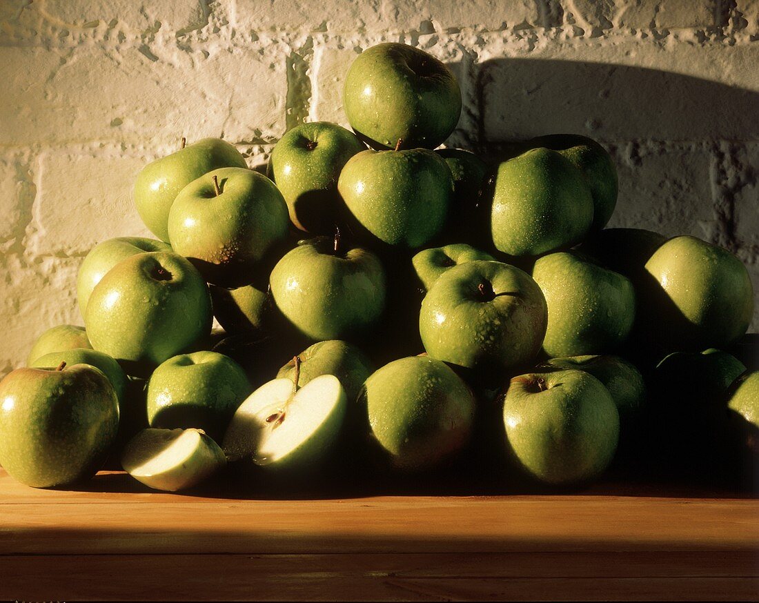 Granny Smith auf einem Haufen vor einer Mauer