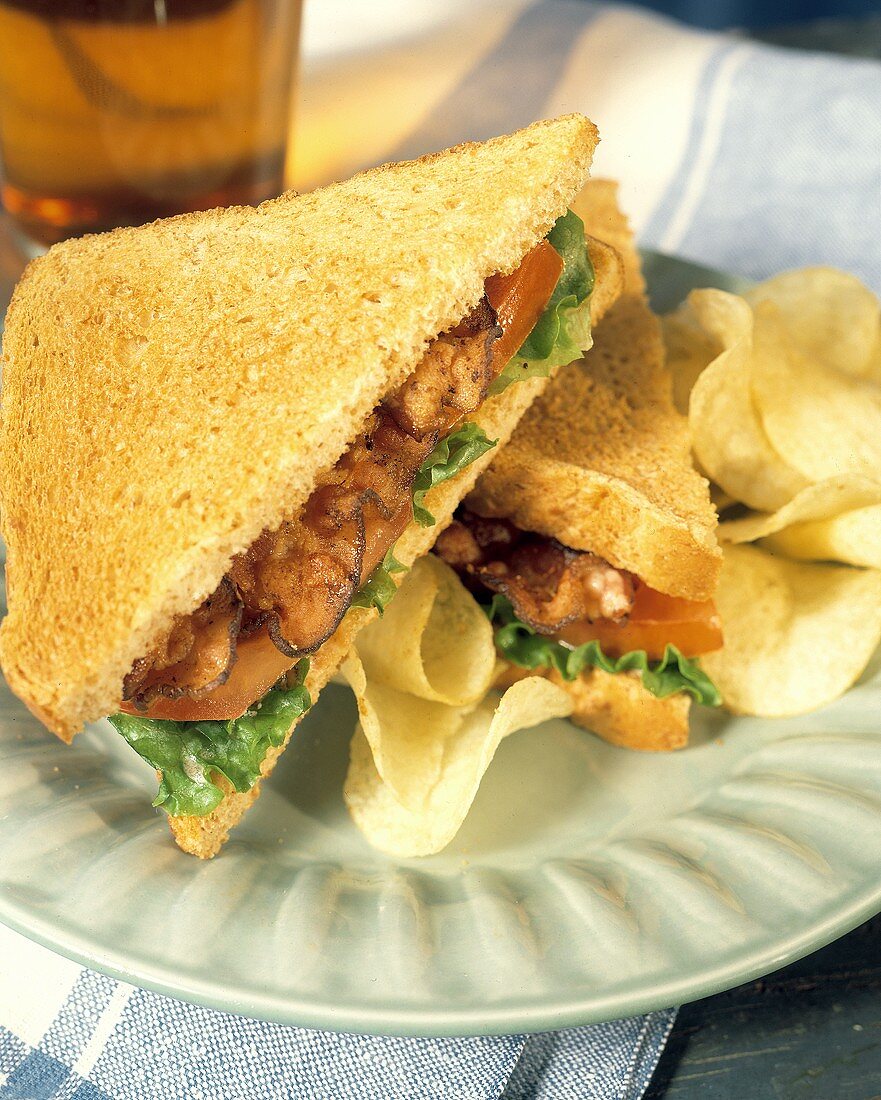 BLT-Sandwich mit Chips auf Teller; Eistee