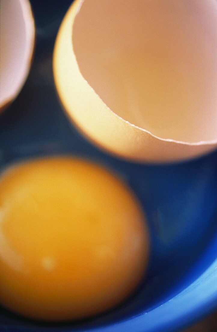 Rohes Ei mit Eierschale in blauem Schälchen
