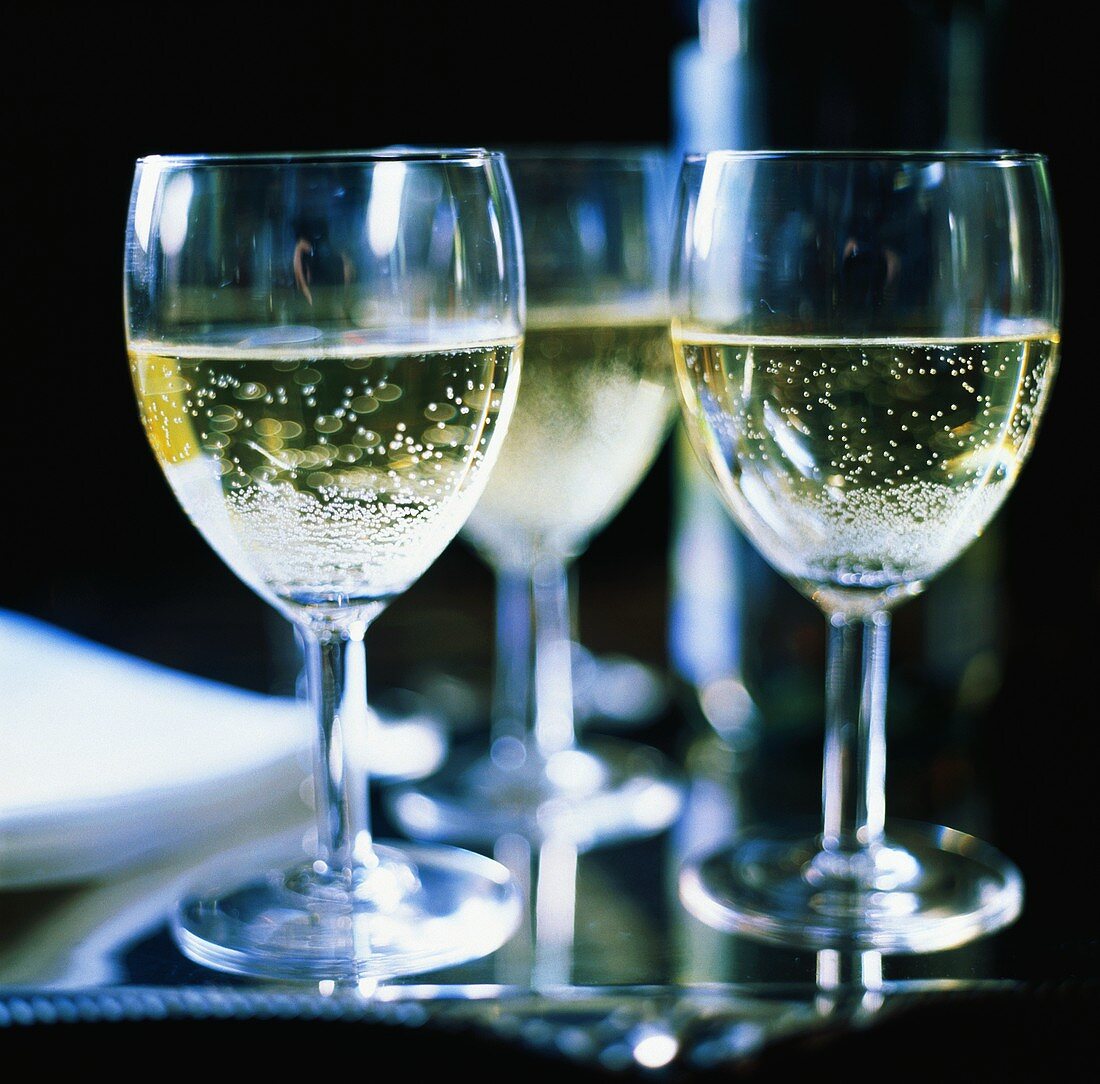 Drei Gläser perlender Weißwein