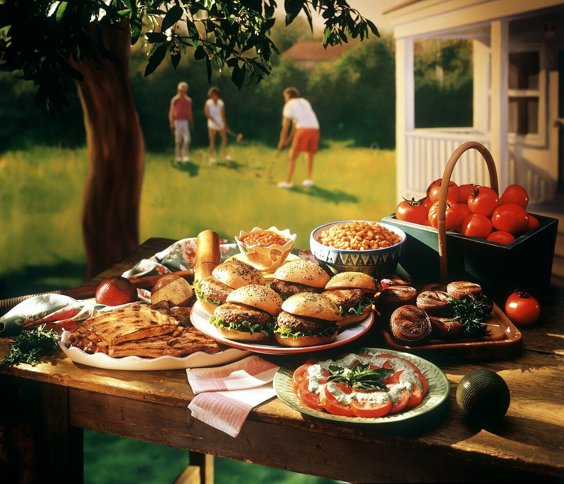 Verschiedene Gerichte auf Gartentisch, dahinter Golfspieler