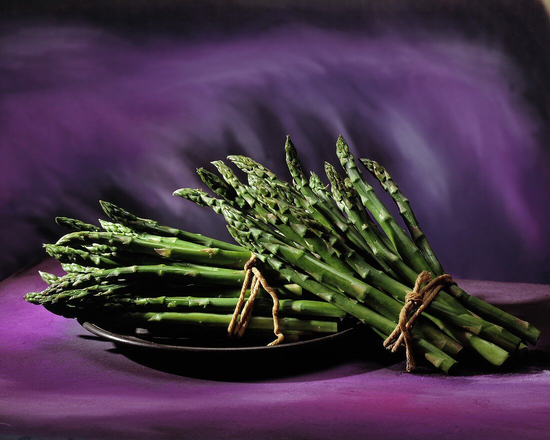Bunches of Green Asparagus; Purple Background