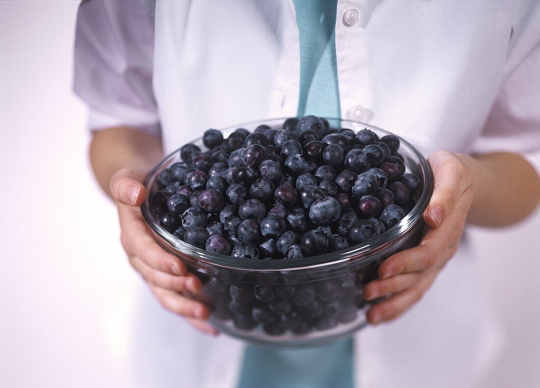 A Bowl of Fresh Blueberries in Child's Hands