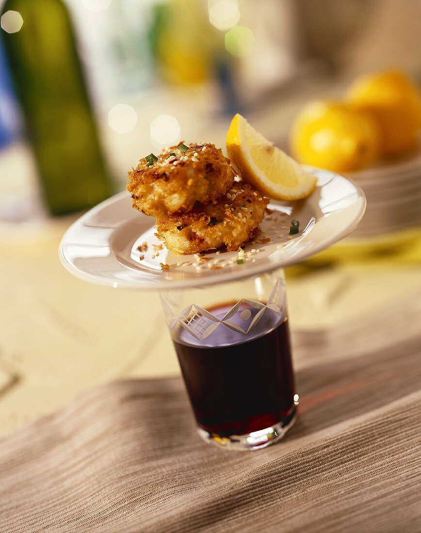 Sesame Crab Cake Tapas on a Glass of Red Wine