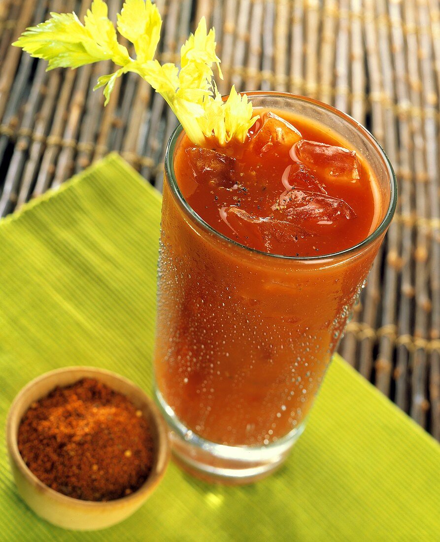A Bloody Mary in a Tall Glass with Celery and a Dish of Hot Pepper