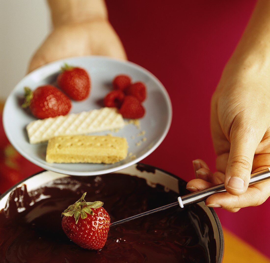 Dipping A Strawberry into Chocolate Fondue