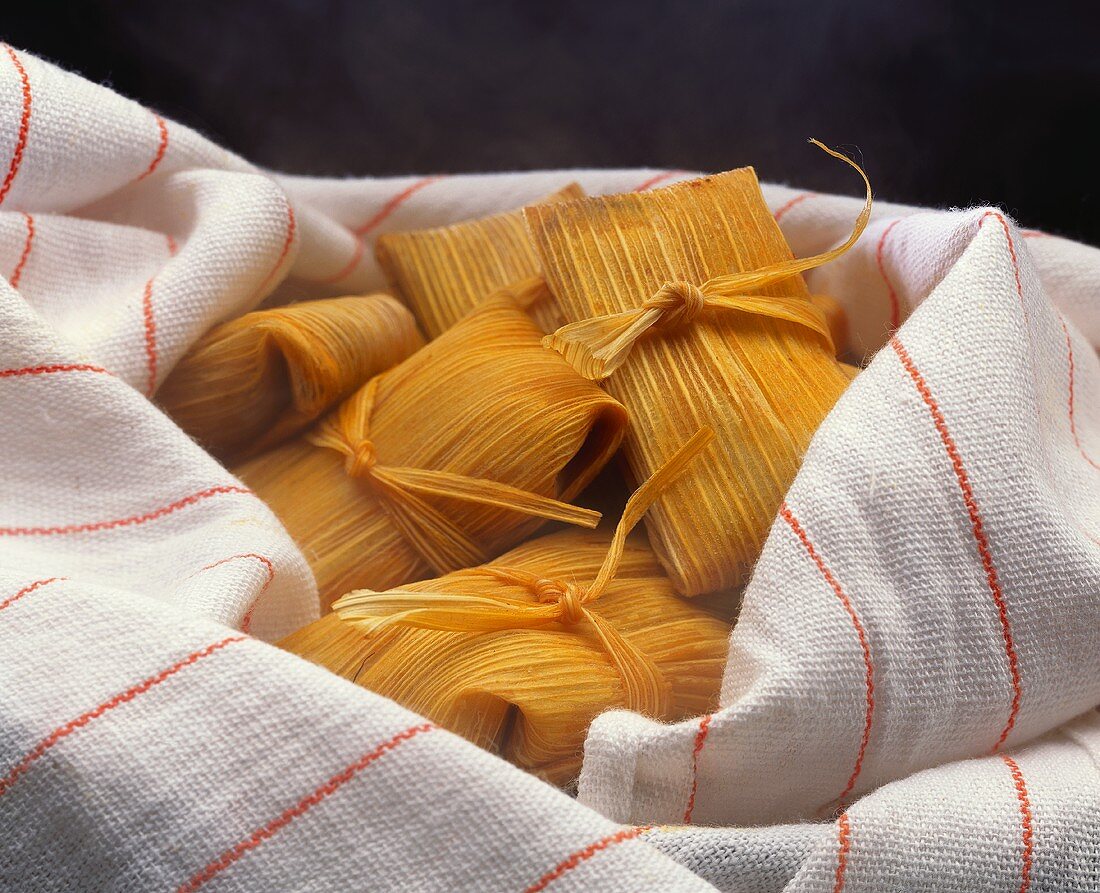 Tamales (gefüllte Maispäckchen aus Mexiko) in Geschirrtuch
