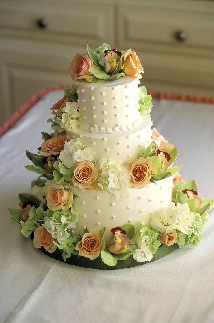 A 3-Tiered Wedding Cake Decorated with Roses and Hydrangeas
