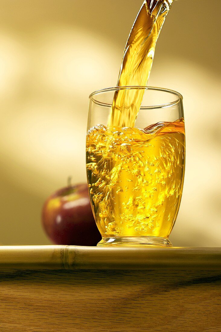 Apfelsaft in Glas einschenken