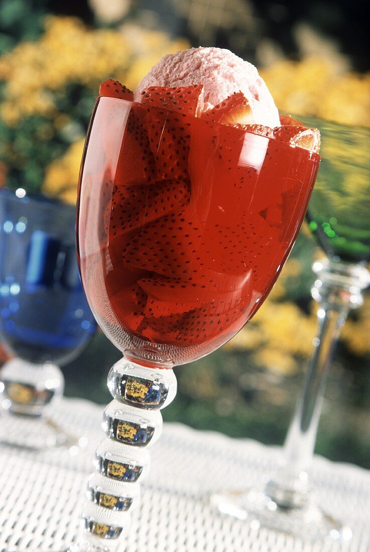 Strawberry ice cream with fresh strawberries in a red beaker