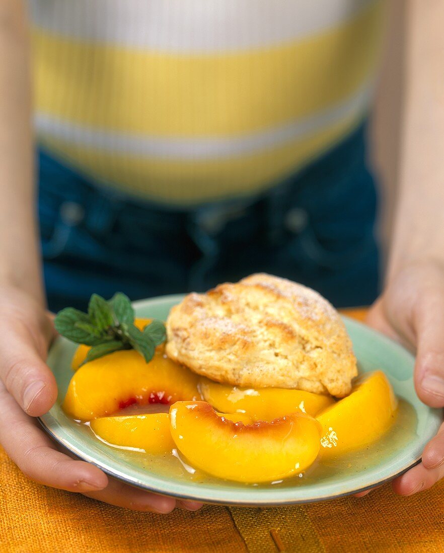 Person holding plate of peach cobbler