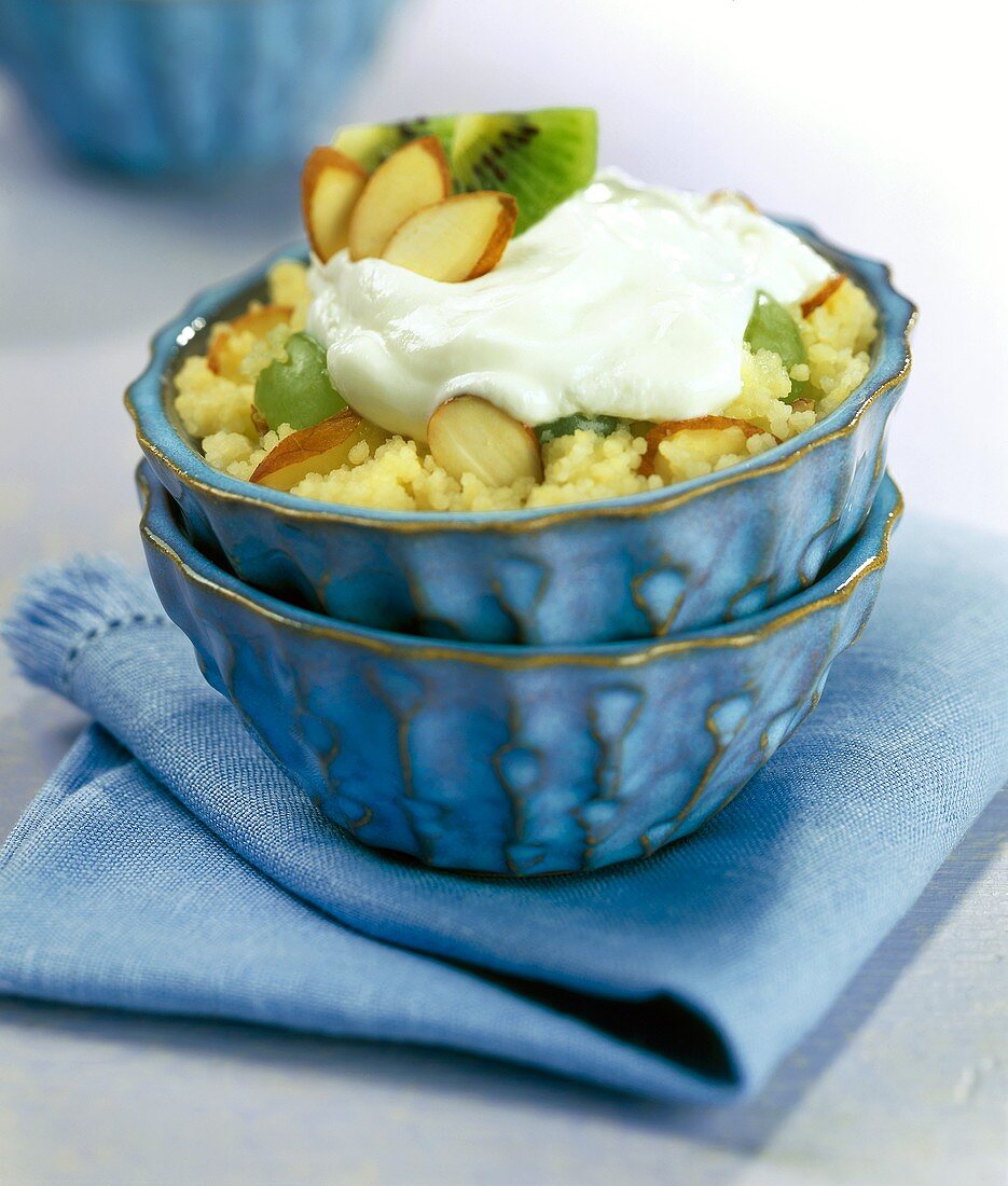 Couscous pudding with almonds, kiwi fruits and cream