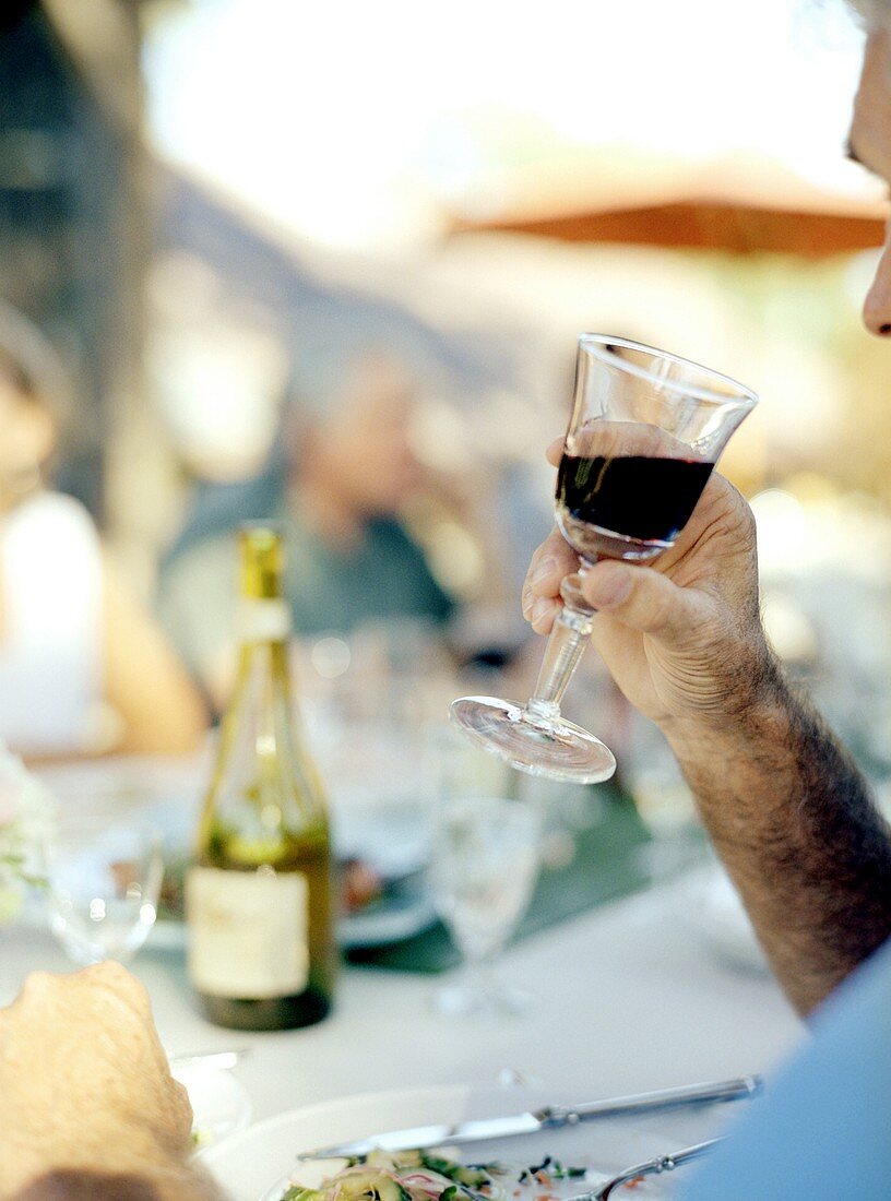 Mann trinkt Glas Rotwein im Restaurant