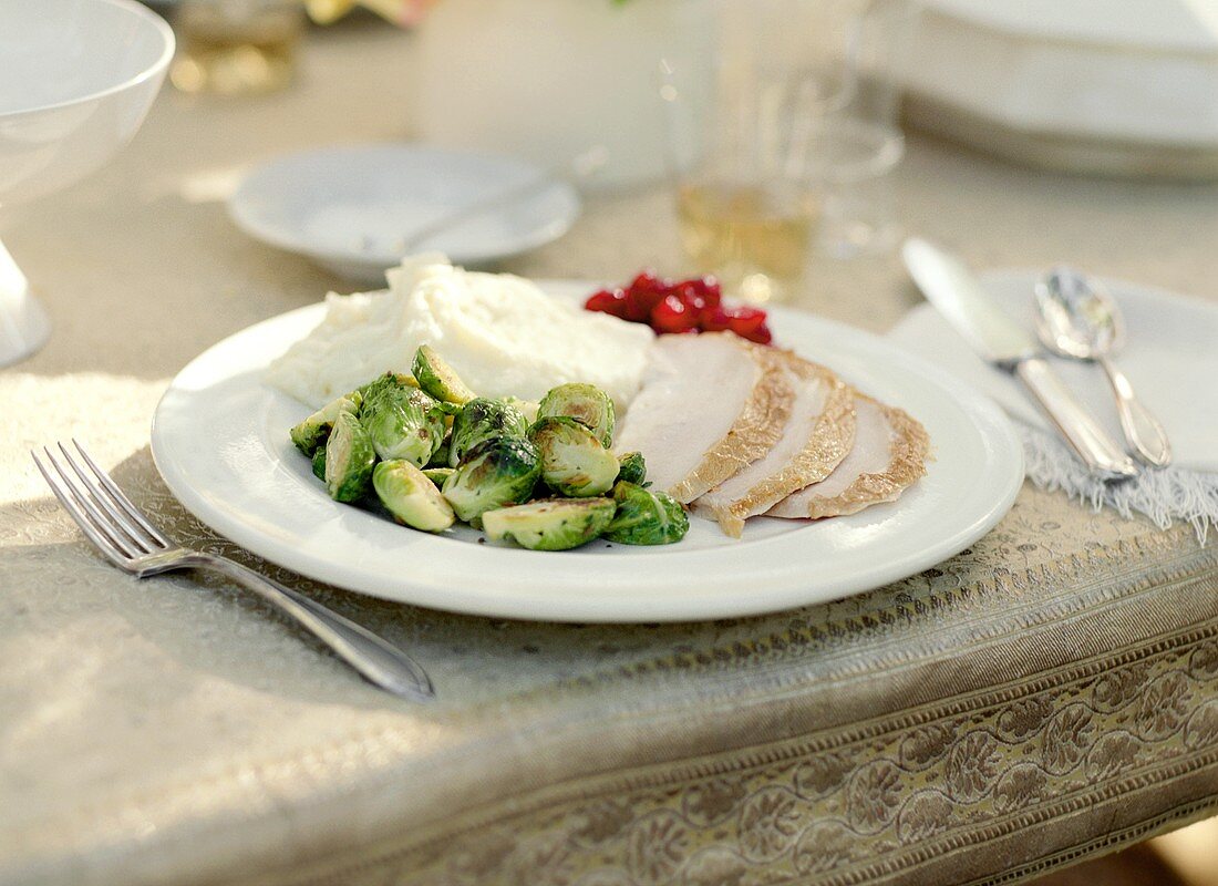 A Plate of Sliced Turkey with Brussel Sprouts and Mashed Potatoes