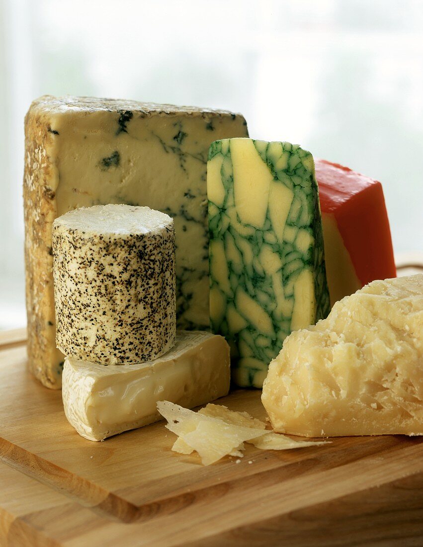 Various types of cheese on chopping board