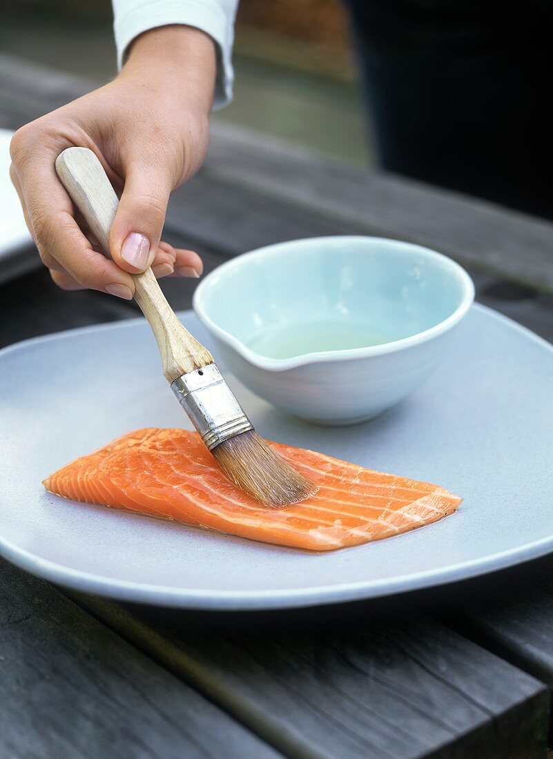 Brushing salmon fillet with oil