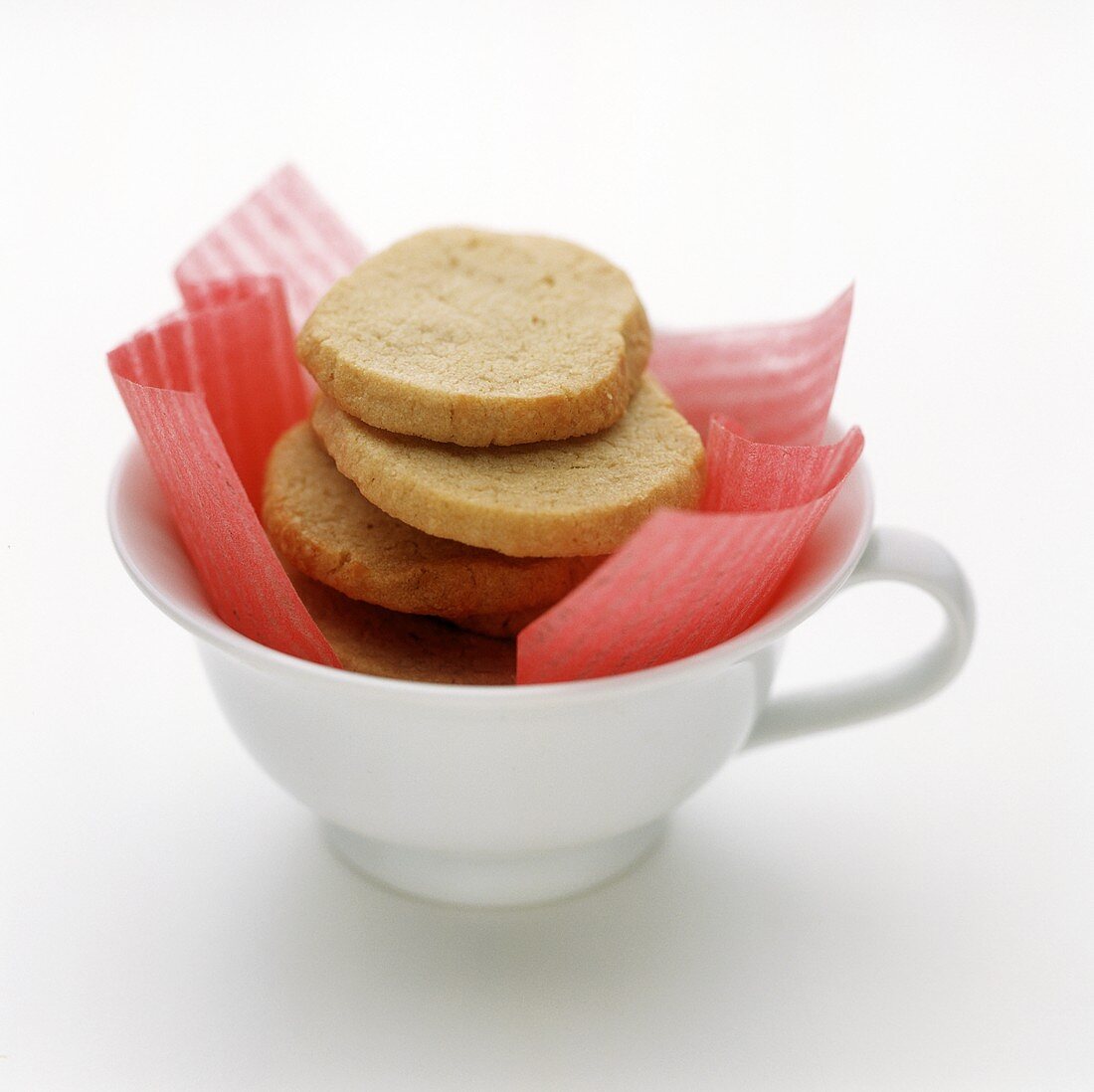 Lemon biscuits in teacup with pink paper