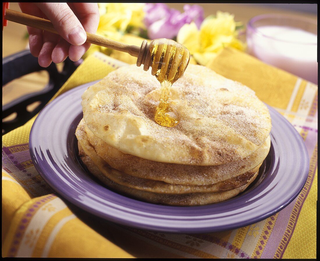 Putting honey on buñelos