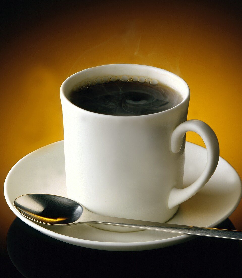 Steaming black coffee in white cup