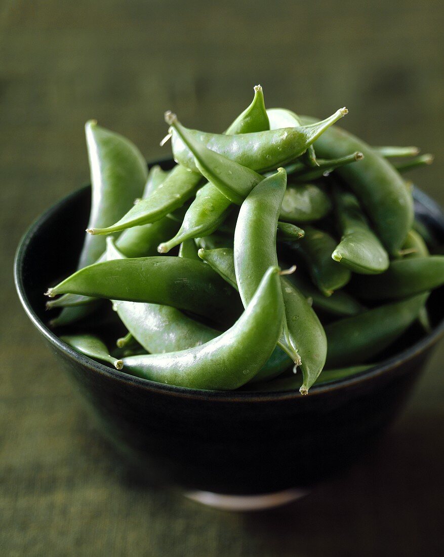 Fresh mangetouts in brown bowl