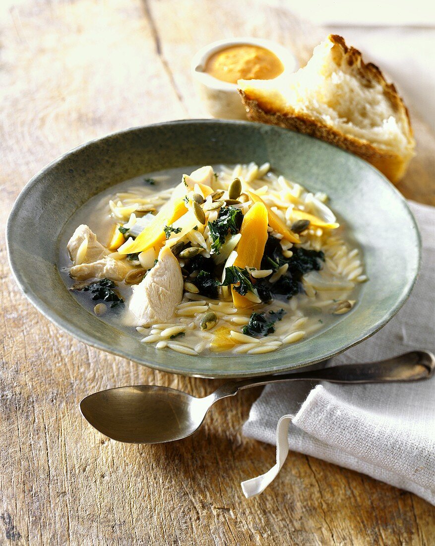 Soup with chicken, rice noodles, carrots and kale
