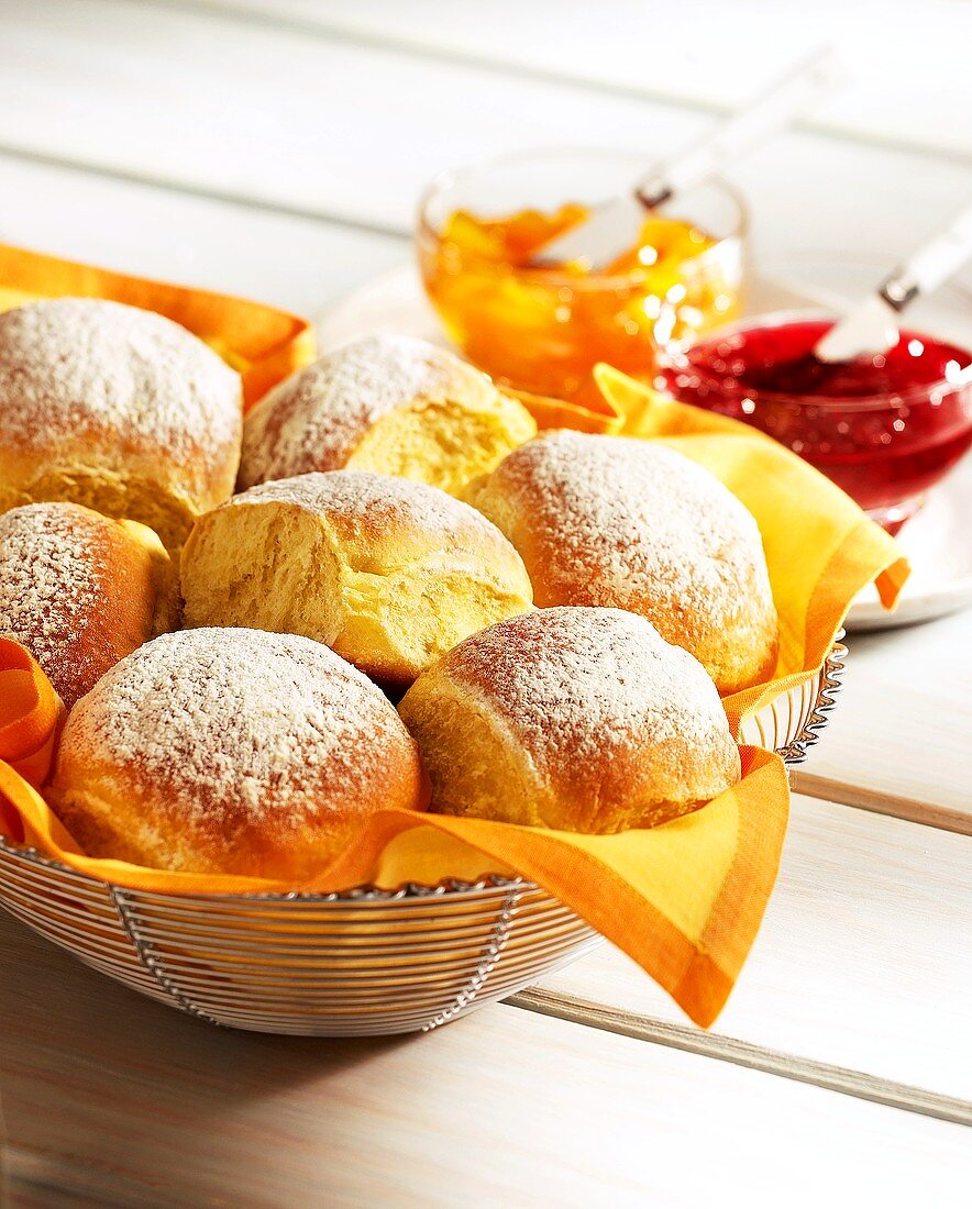 Kartoffelbrötchen im Brotkorb, daneben Marmelade