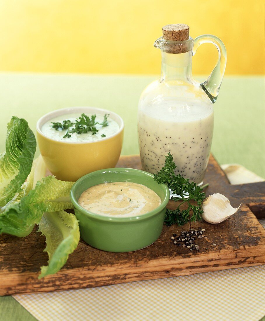 Various salad dressings on chopping board