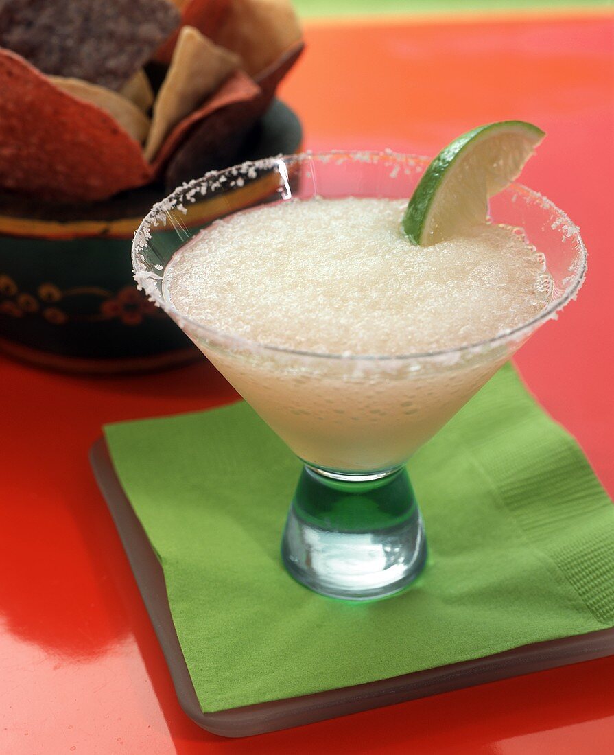 Frozen Margarita with lime in glass with salted rim