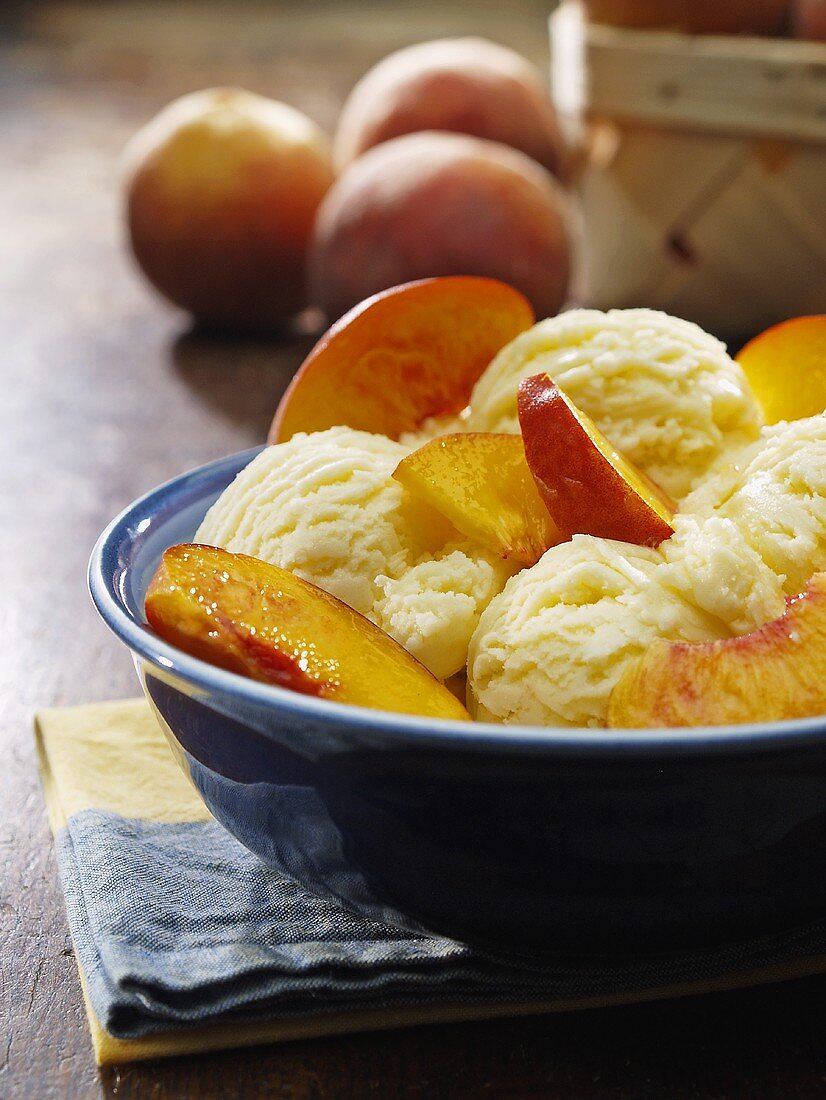 Eine Eisschale mit Vanilleeis und Pfirsichschnitzen