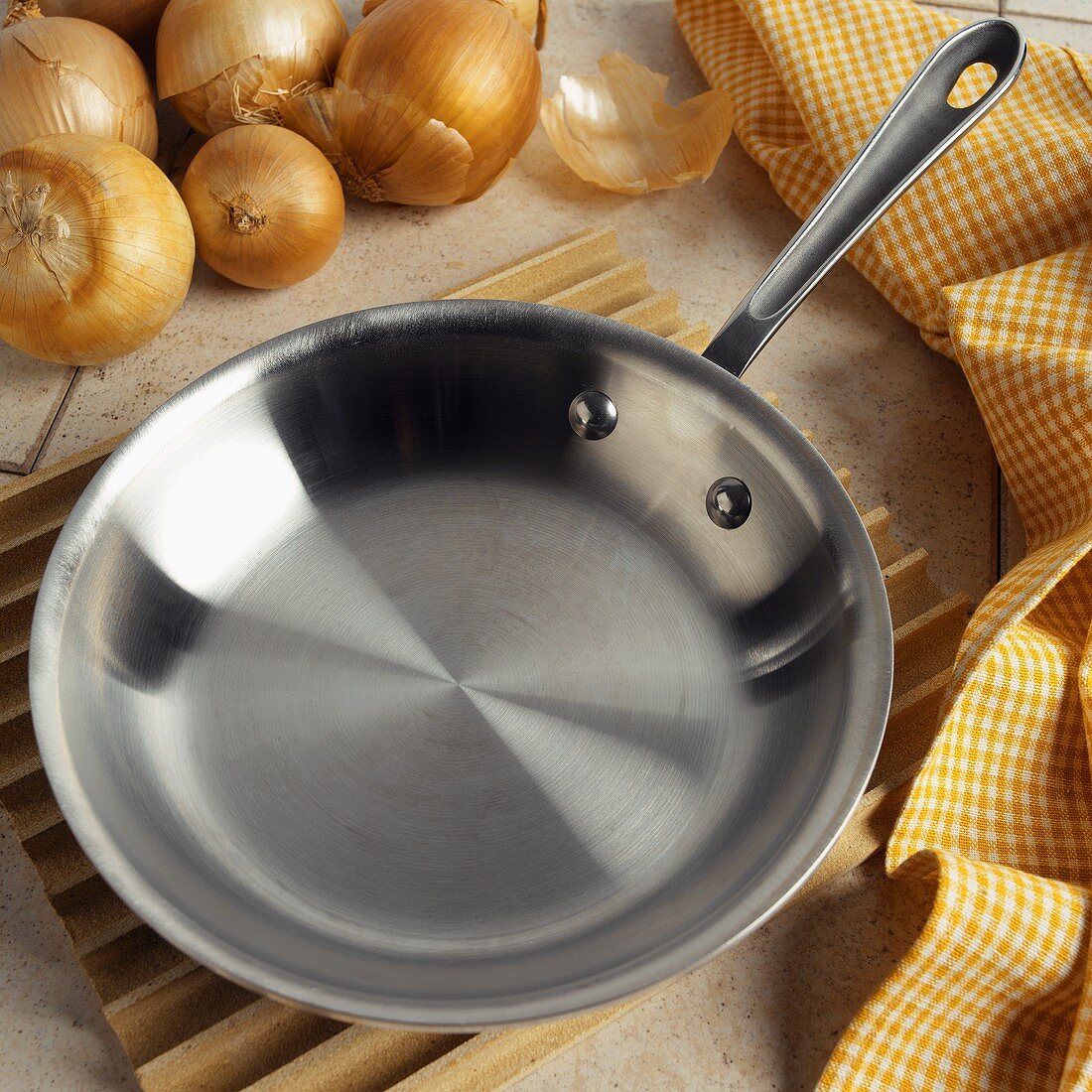 An Empty Saute Pan with Onions and a Yellow Towel