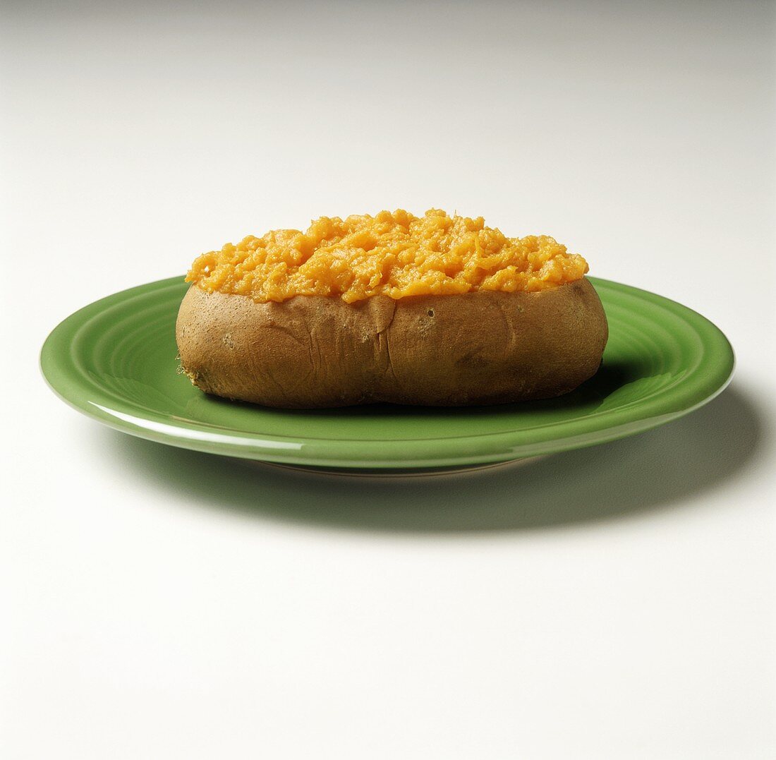 A Baked Sweet Potato on a Green Plate