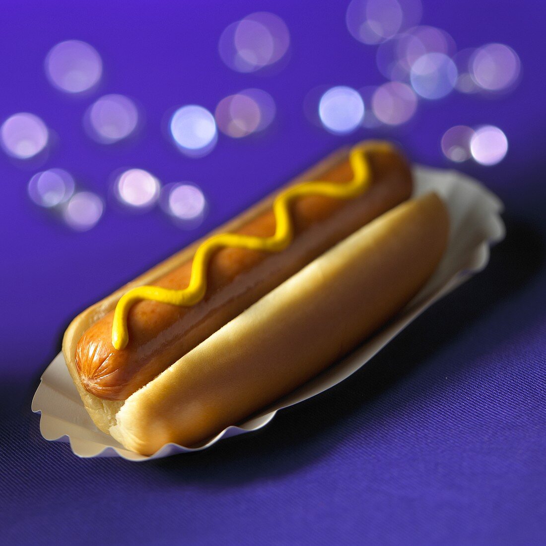Hot dog with mustard in cardboard tray