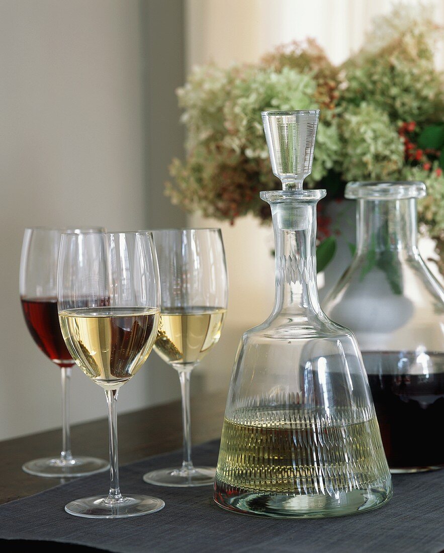 Karaffen und Gläser mit Rot- und Weißwein