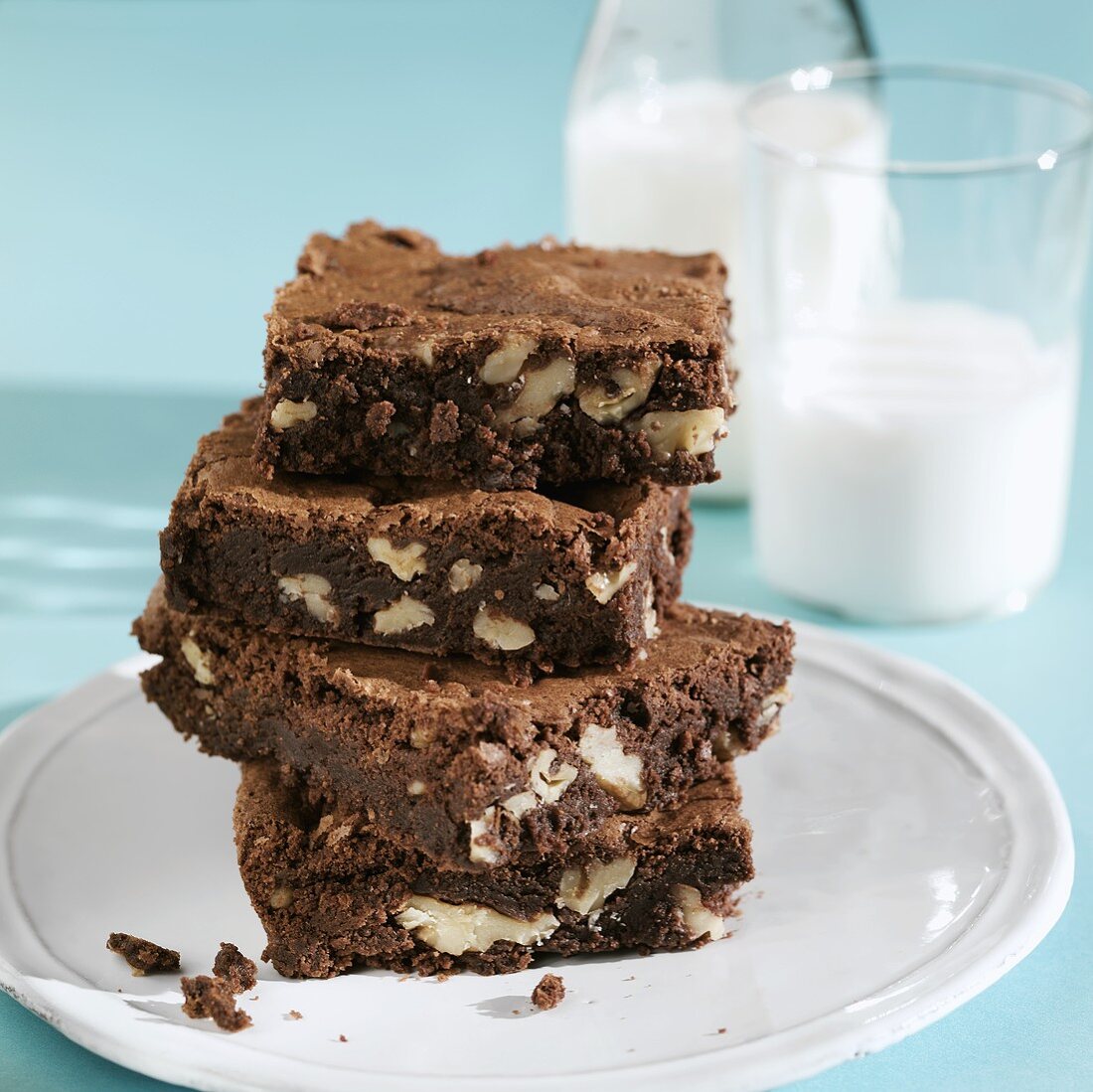 A Stack of Walnut Chocolate Brownies with a Glass and Bottle of Milk