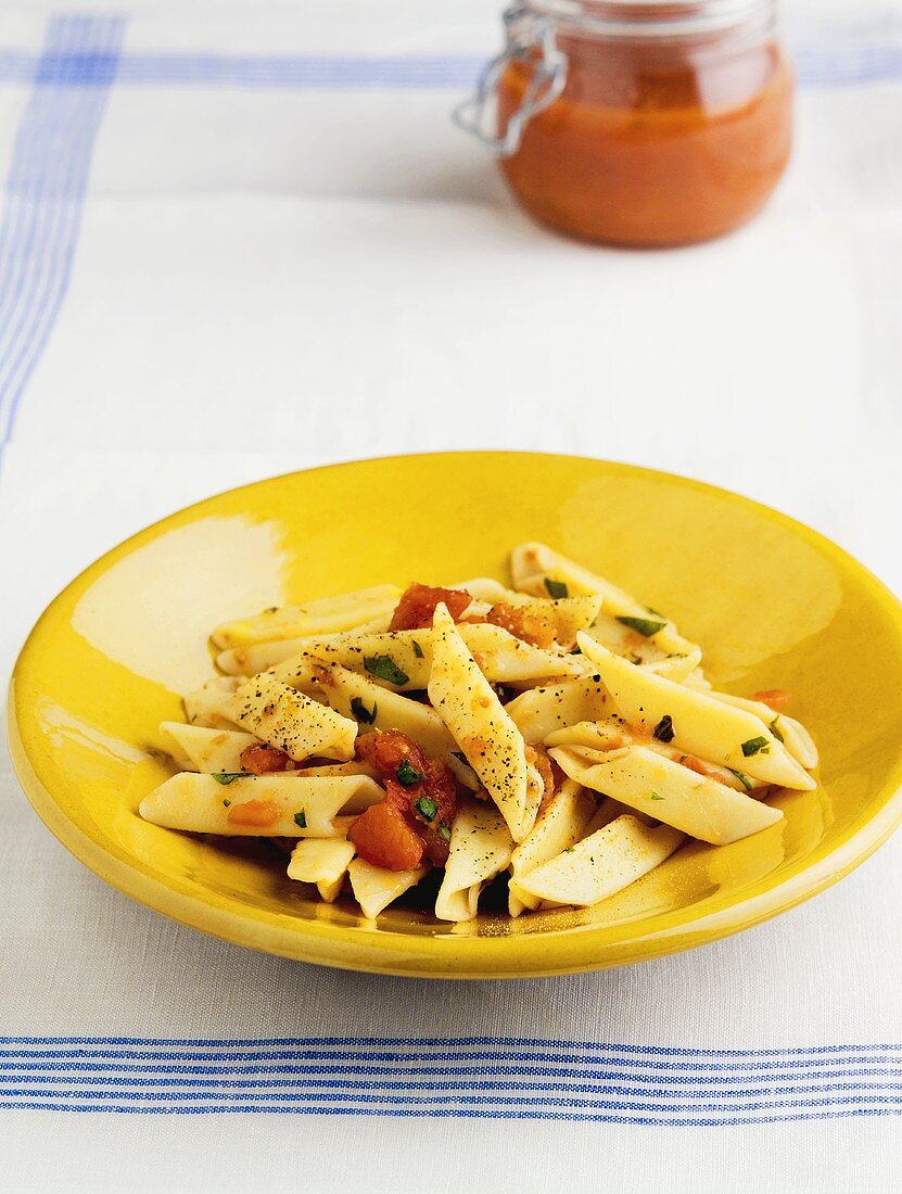 Penne mit Pfeffer und Tomaten auf gelbem Teller