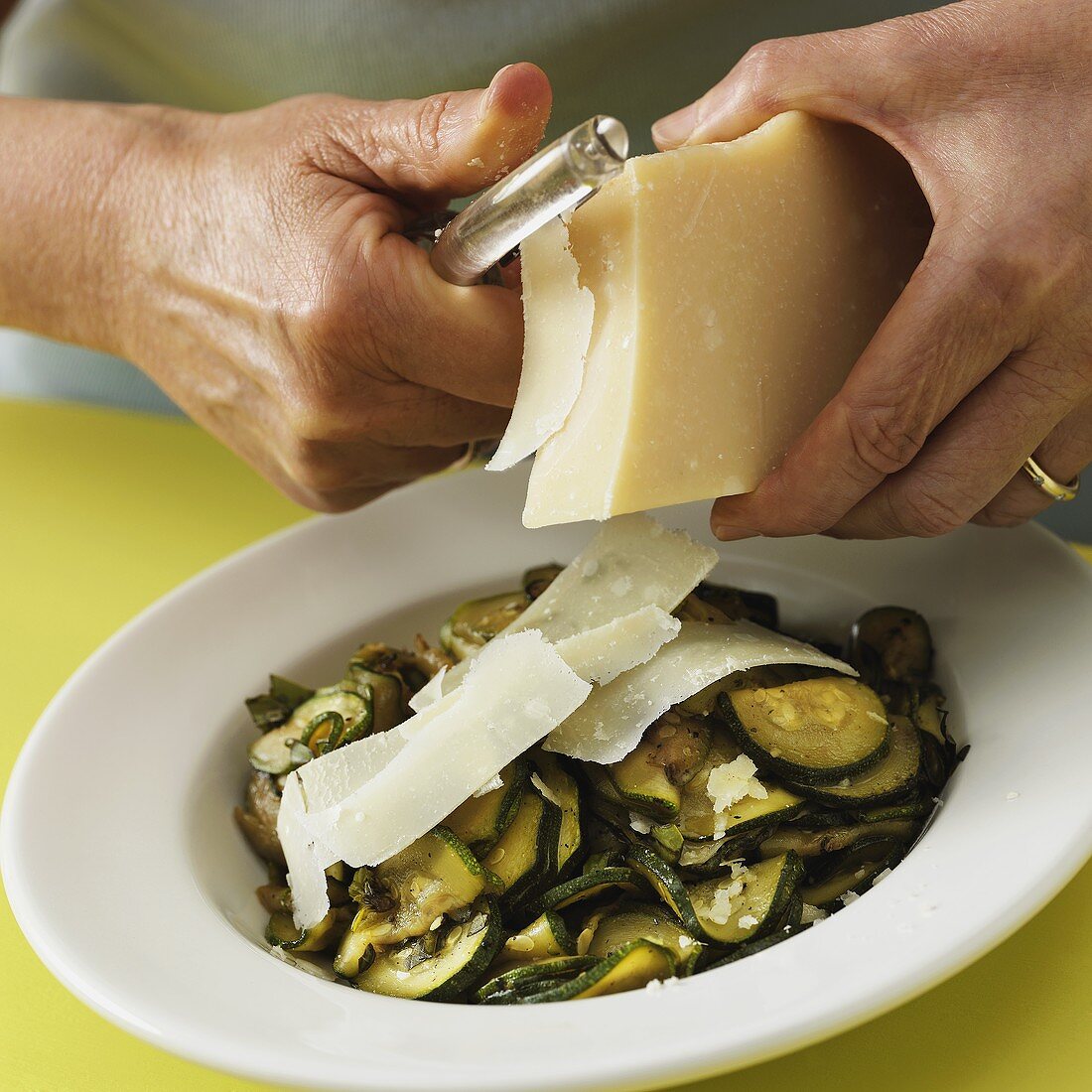 Shaving Parmesan onto Cooked and Sliced Zucchini