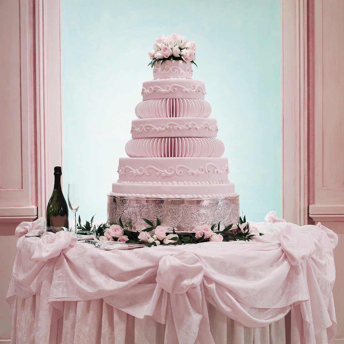 A Multi-tiered Wedding Cake on a Table with Champagne