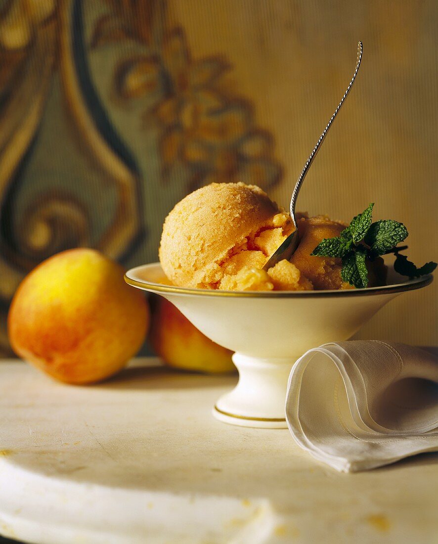 Peach Ice Cream in a Pedestal Bowl with Fresh Mint