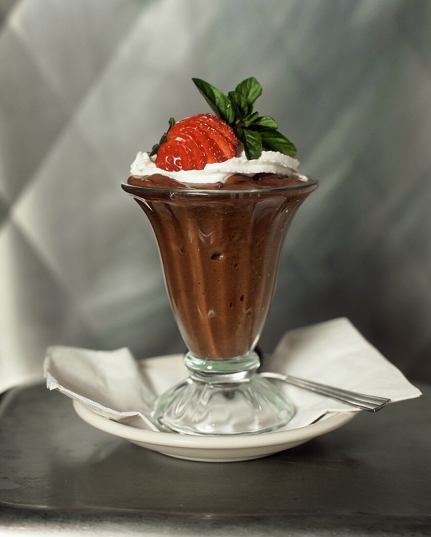 Schokoladenpudding mit Sahne, Minze und Erdbeere im Glas