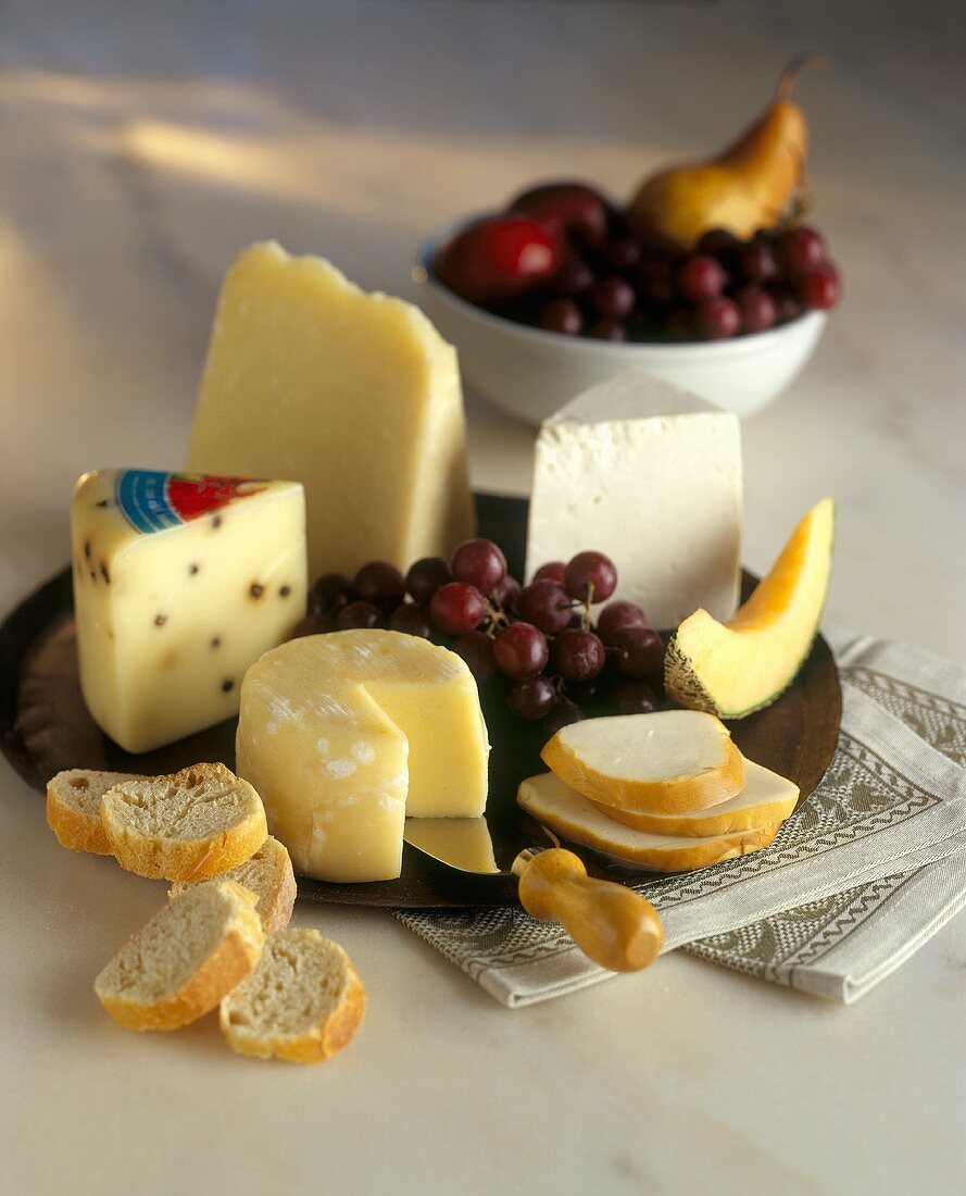 Verschiedene Käsesorten mit Obst und Baguette