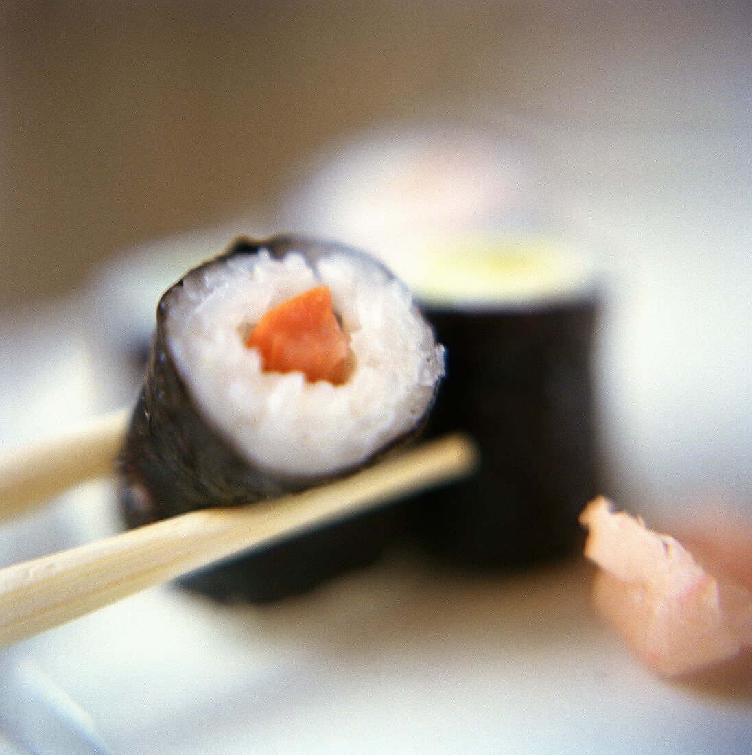 Chopsticks Holding a Maki Sushi