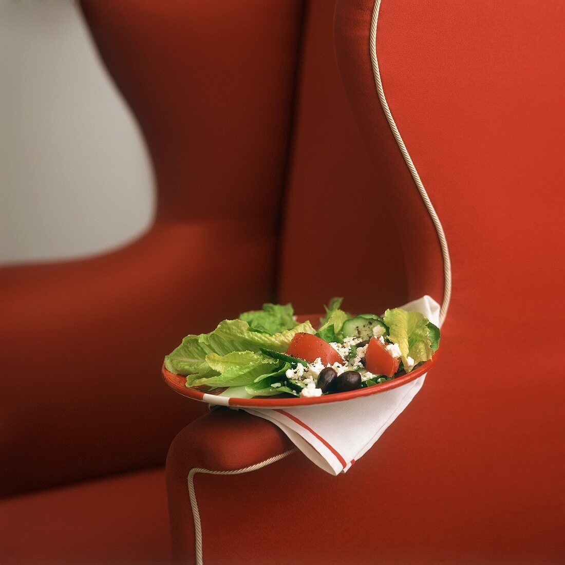 Griechischer Salat auf rotem Stuhl