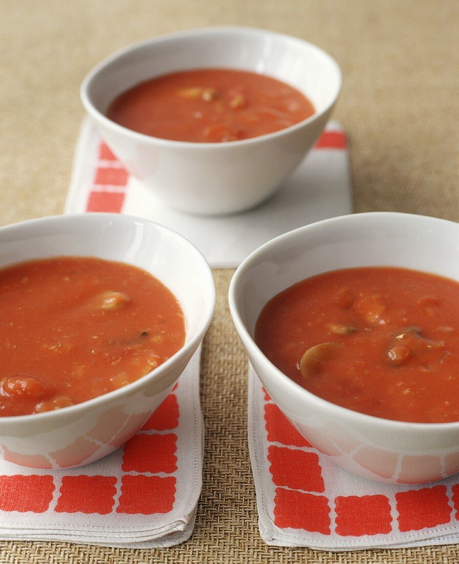 Drei Tomatensuppen in weissen Schalen